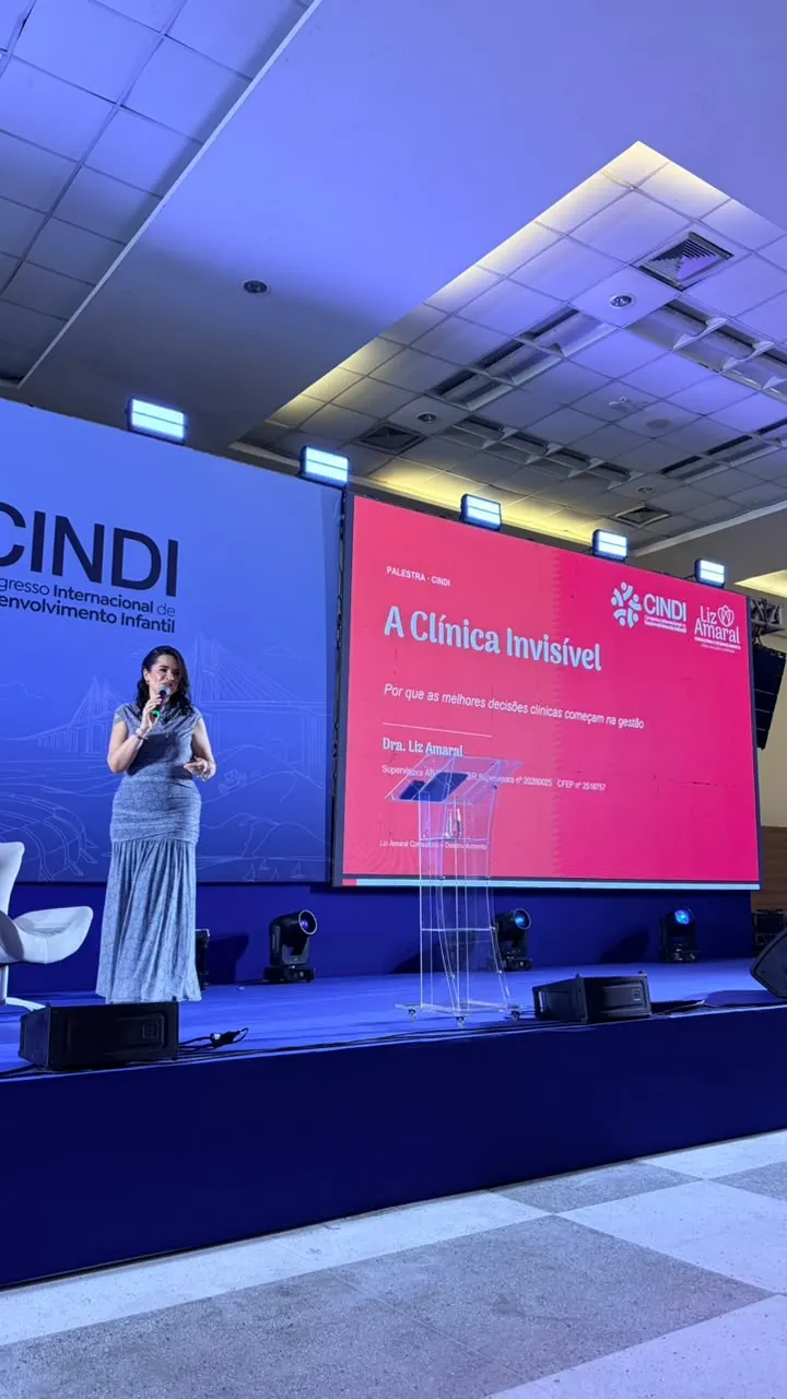 Dra. Liz Amaral palestrando no CINDI, com o tema "A Clínica Invisível" no telão